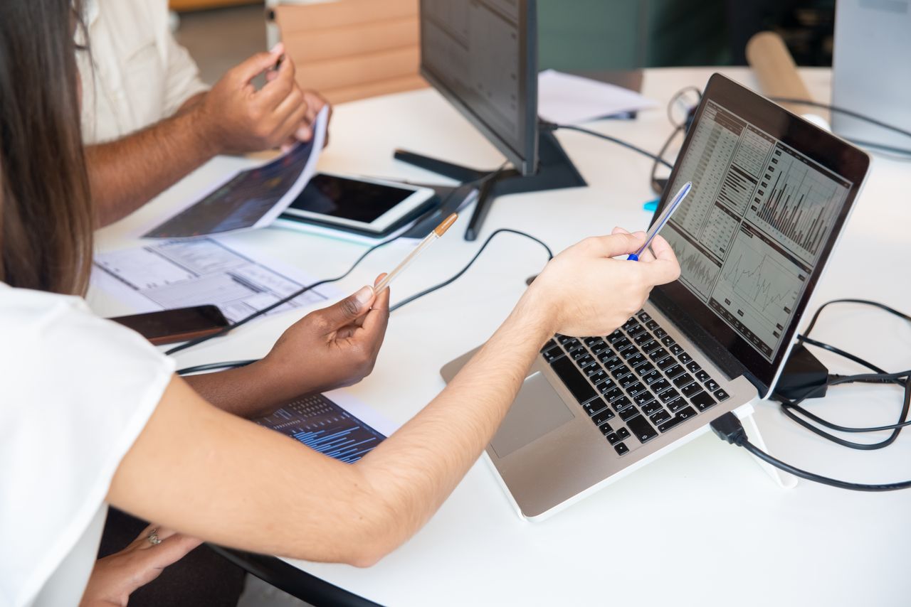Crafting Captivating Headlines: Your awesome post title goes here Professionals analyzing data charts on a laptop in an office setting, collaboratively discussing insights.